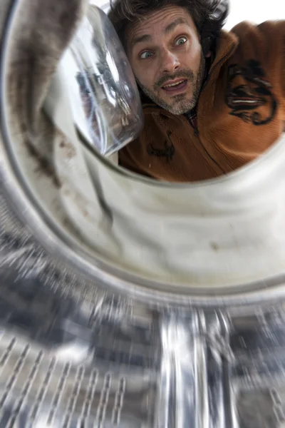 Surprised man open a washing machine — Stock Photo, Image