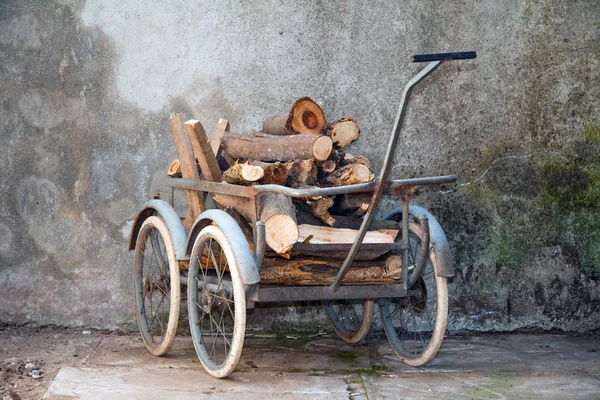 Carrinho de mão com uma carga de madeira — Fotografia de Stock