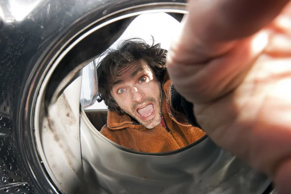 Человек открывает стиральную машину — стоковое фото