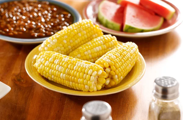 Meal with corn on a cob on a plate — стоковое фото