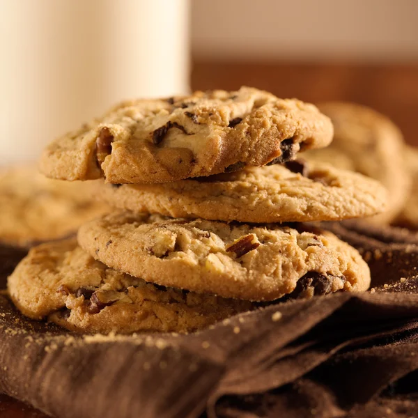 Čokoláda čip cookies a sklenici mléka v pozadí — Stock fotografie