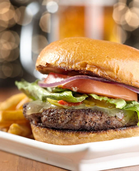 Bira arka planda bir fincan gurme çizburger — Stok fotoğraf