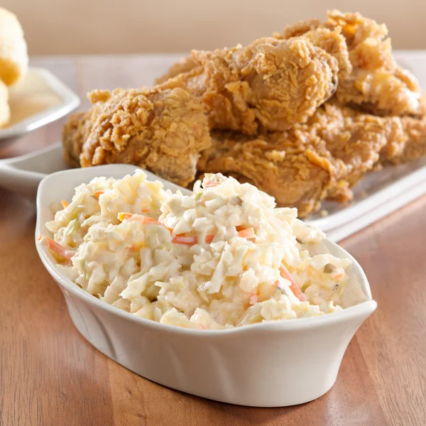 Coleslaw with fried chicken in background. — Stock Photo, Image