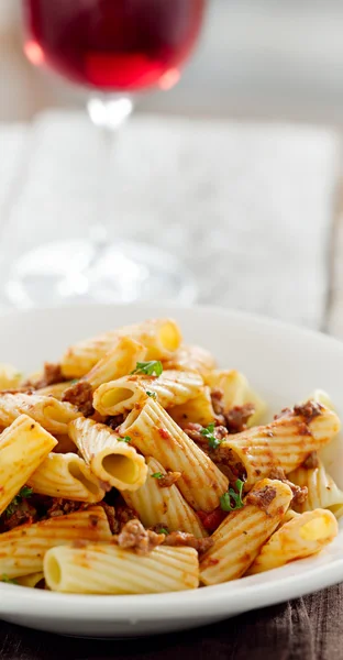 Rigatoni pasta with tomato meat sauce and wine — Stock Photo, Image