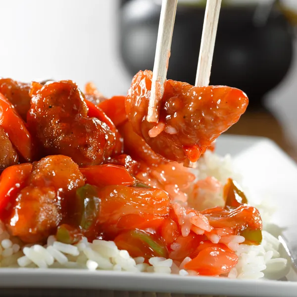 Süß-saures Schweinefleisch auf Reis mit Stäbchen — Stockfoto