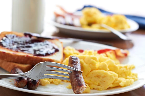 Links de salsicha sendo pego por um garfo em um grande café da manhã . — Fotografia de Stock