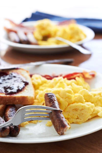 Links de salsicha sendo pego por um garfo em um grande café da manhã . — Fotografia de Stock