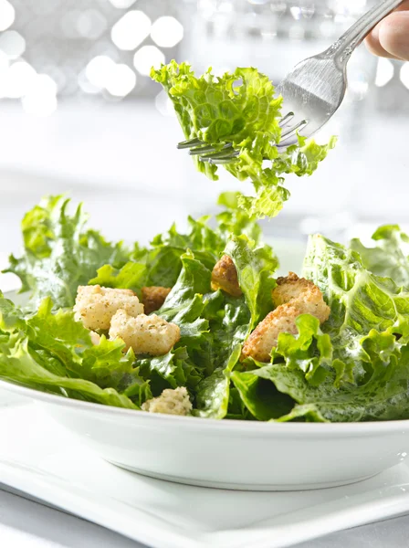 Eating a leafy green salad with fork — Stock Photo, Image