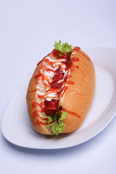 Delicious hot dog with many sauce on a white — Stock Photo, Image
