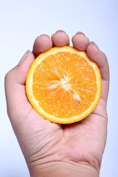 Meia fruta laranja na mão humana — Fotografia de Stock