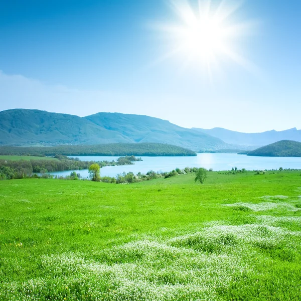 Paisaje de montaña de primavera con un lago y un prado — Foto de Stock