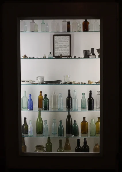 Bottiglie di vetro su scaffali di vetro — Foto Stock