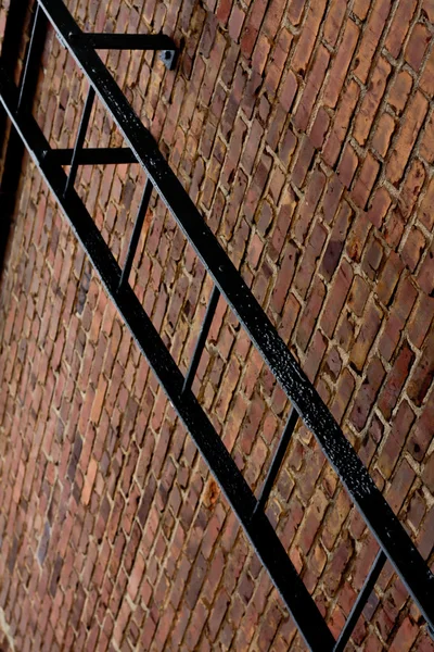 Металлическая лестница на кирпичной стене — стоковое фото