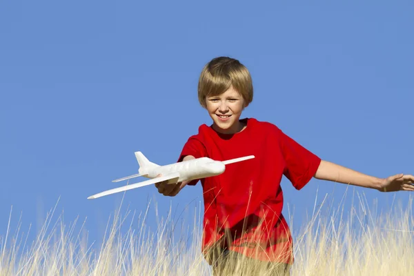 stock image Young Boy Playing with Toy Glider Airplane in Field