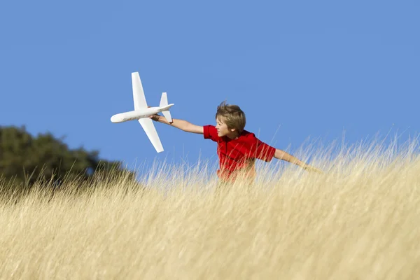 stock image Young Boy Playing with Toy Glider Airplane in Field