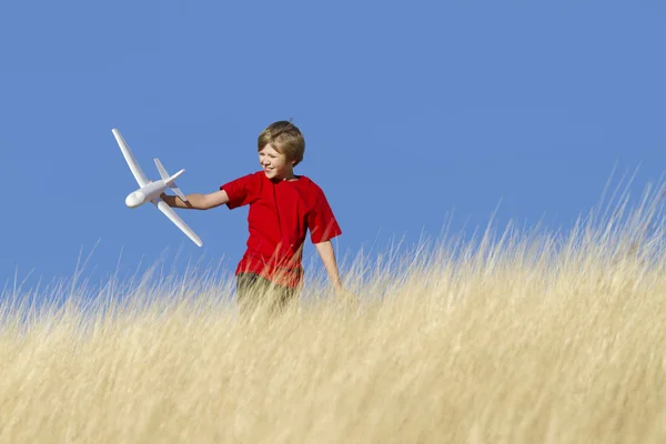 stock image Young Boy Playing with Toy Glider Airplane in Field