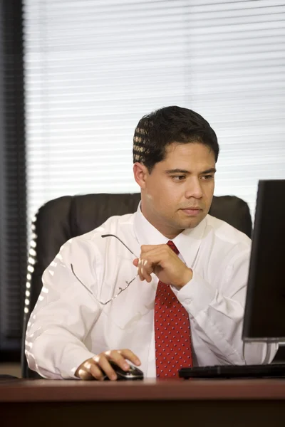 Homme d'affaires hispanique au bureau Image En Vente