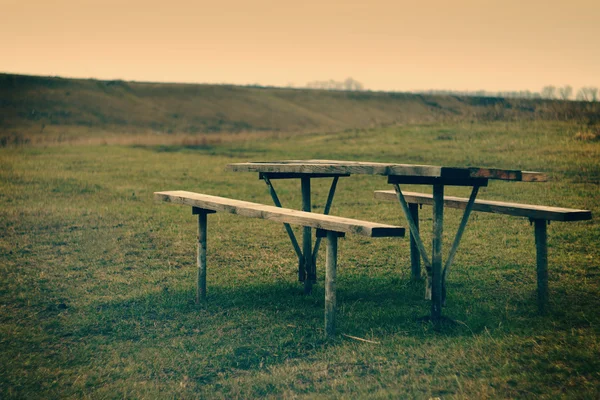 stock image Picnic table on the river. Vintage look