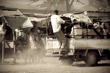 Men catch a ride uphill in Kenya clipart