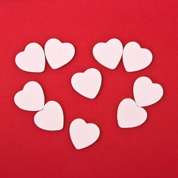 Vita hjärtan på röd bakgrund — Stockfoto