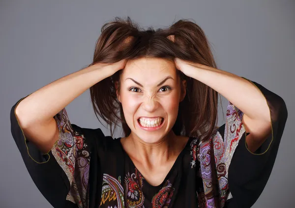 Vrouw benadrukt is gek trekken van haar haren in frustratie. — Stockfoto
