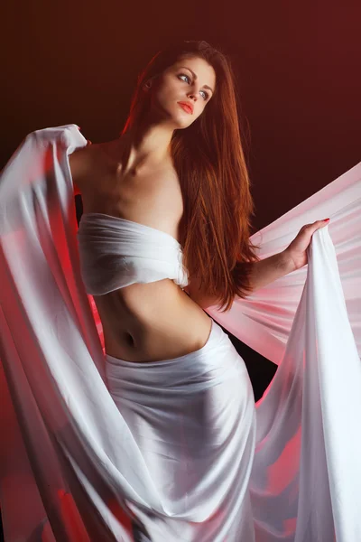Mulher bonita com um pano branco em um fundo vermelho — Fotografia de Stock