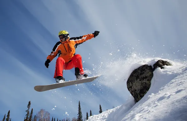 Snowboarder springt mit blauem Himmel durch die Luft Stockfoto