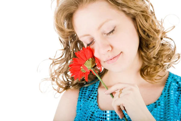 Schöne junge blonde lockige Frau mit einer Blume in ihren Händen — Stockfoto