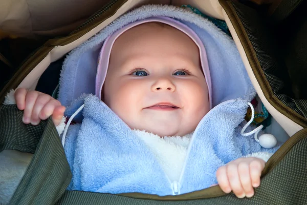 Sorrindo bebê menina em uma cadeira de rodas — Fotografia de Stock