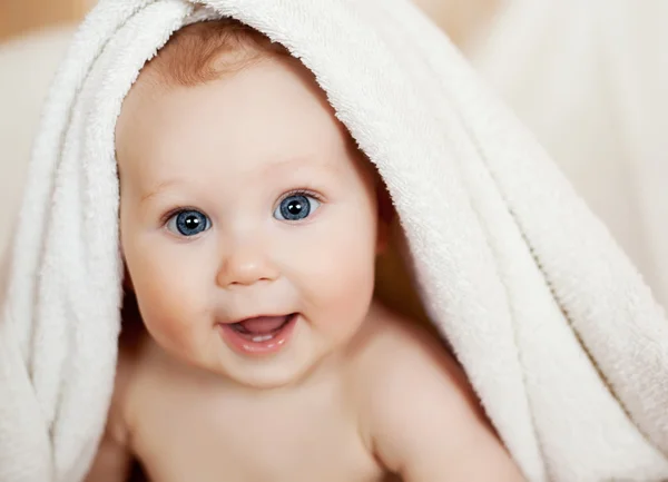 Прекрасный улыбающийся ребенок, завернутый в одеяло — стоковое фото