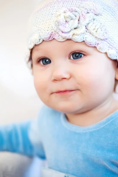 Усміхнена дівчинка показує зуби в капелюсі з квіткою ізольовані на білому — стокове фото