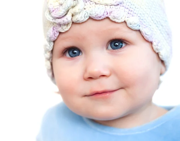 Χαμογελώντας μωρό κορίτσι Εμφάνιση δόντια φορώντας ένα καπέλο με λουλούδι που απομονώνονται σε λευκό — Φωτογραφία Αρχείου