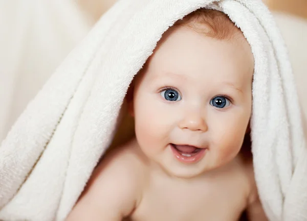 Un hermoso bebé sonriente envuelto en edredón —  Fotos de Stock