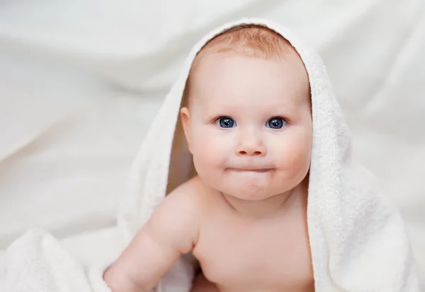 Piękne uśmiechający się dziecko owinięte w kołdry — Zdjęcie stockowe