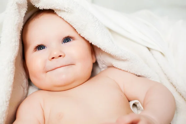 Un beau bébé souriant enveloppé dans la courtepointe — Photo
