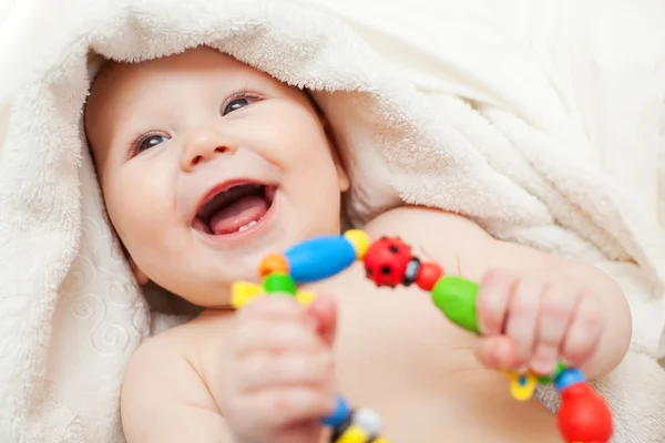 Красива усміхнена дитина, загорнута в ковдру — стокове фото
