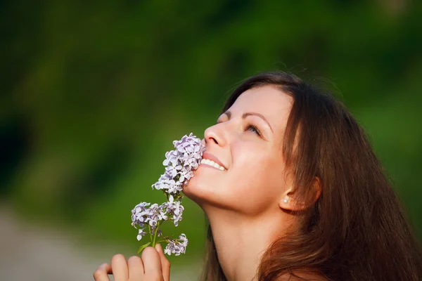 Mutlu genç kadın ve yabani çiçekler — Stok fotoğraf