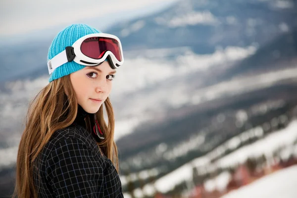 Portret van een jonge vrouw tegen een achtergrond van de bergen — Stockfoto