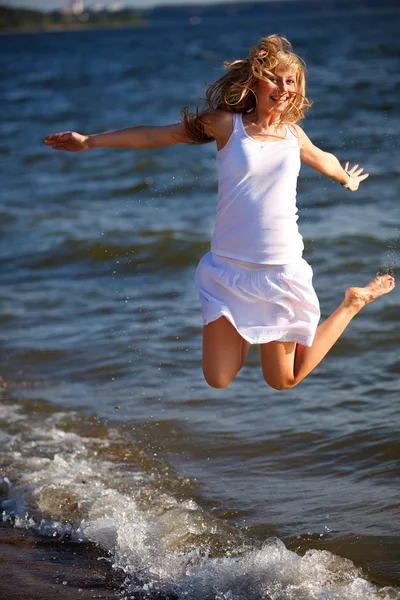 Ljusa foto av en vacker flicka som avkopplande på en strand — Stockfoto