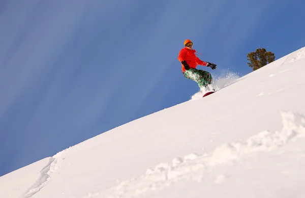 Snowboarder facendo una punta laterale intagliare con cielo blu profondo in background — Foto Stock