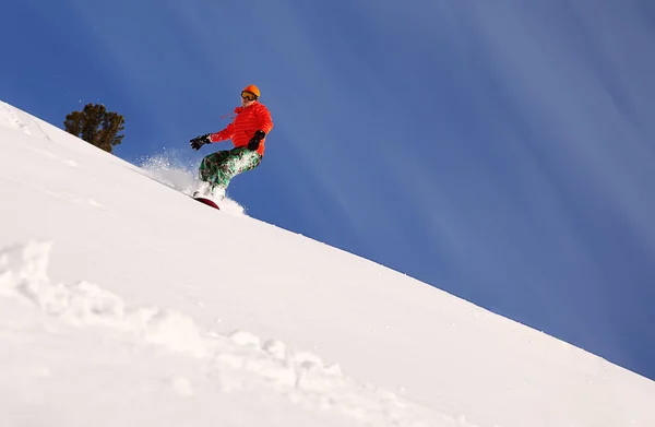 Snowboardåkare gör en tå sida rista med djupa blå himmel i bakgrunden — Stockfoto
