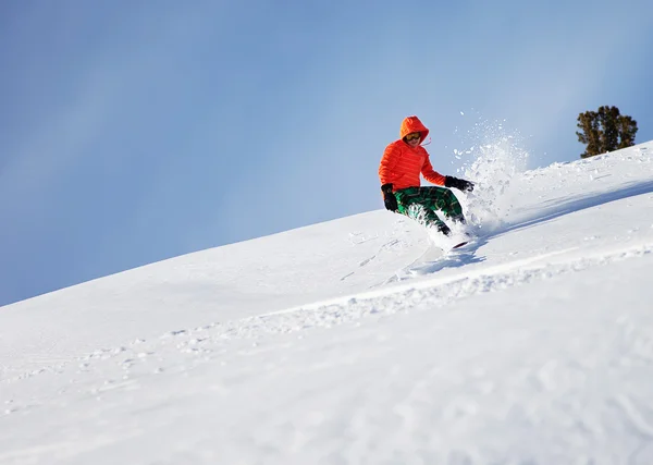 stock image Snowboarder doing a toe side carve with deep blue sky in background