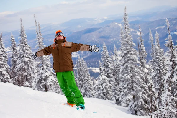 Snowboardzista na górze z uniesionymi ramionami — Zdjęcie stockowe