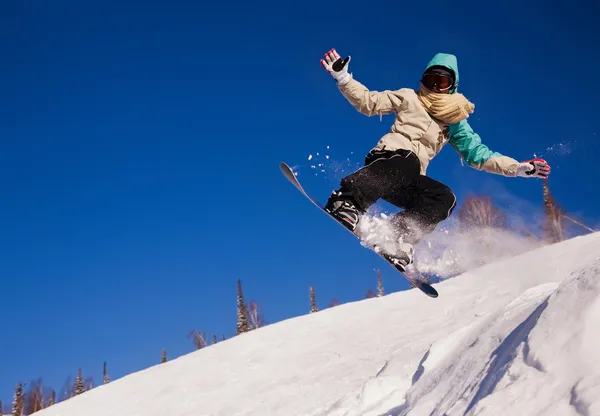 Сноубордист прыгает по воздуху с глубоким голубым небом на заднем плане — стоковое фото