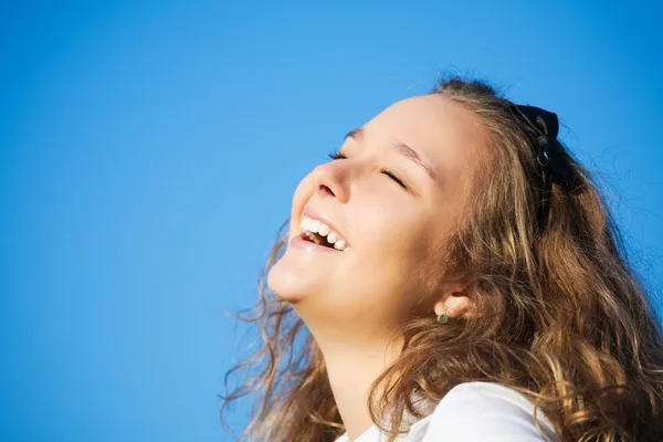 Beautiful girl on a blue sky background Royalty Free Stock Photos