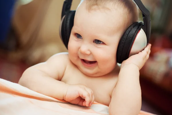 Bebê sorridente com fone de ouvido Imagem De Stock