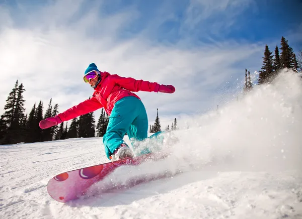 Snowboarder springt durch die Luft mit tiefblauem Himmel im Hintergrund lizenzfreie Stockbilder