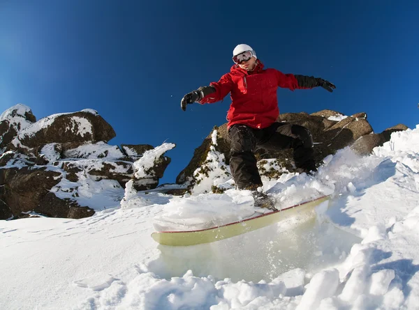 Snowboarder fazendo um dedo do pé lado esculpir com céu azul profundo no fundo — Fotografia de Stock