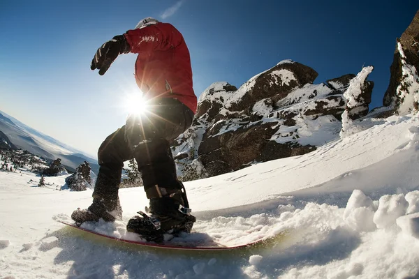Snowboarder doing a toe side carve with deep blue sky in background — Stock Photo, Image