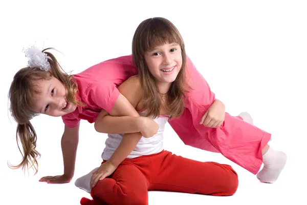 Glücklich lächelnde kleine Schwestern auf weißem Hintergrund — Stockfoto